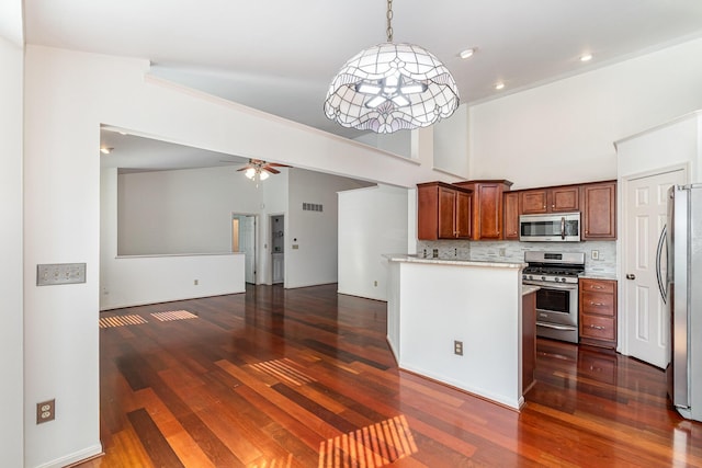 kitchen with dark wood-style flooring, ceiling fan, light countertops, appliances with stainless steel finishes, and backsplash