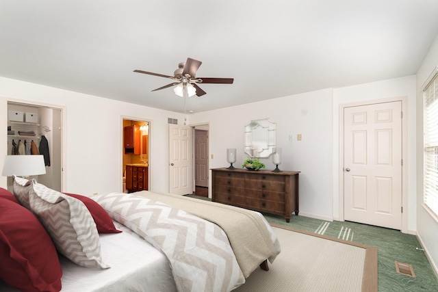 carpeted bedroom with connected bathroom, baseboards, and ceiling fan