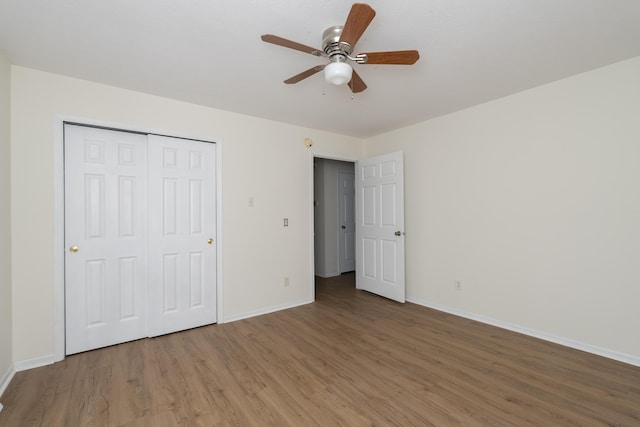 unfurnished bedroom featuring a ceiling fan, a closet, baseboards, and wood finished floors