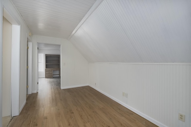 bonus room featuring lofted ceiling, baseboards, and wood finished floors