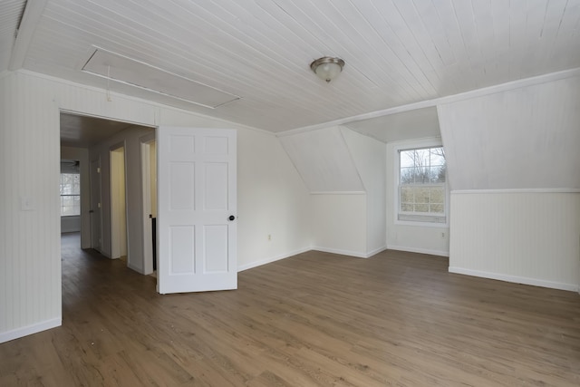 additional living space featuring attic access, baseboards, wood ceiling, wood finished floors, and vaulted ceiling