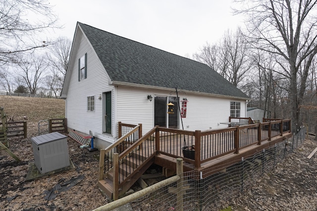 back of house featuring a shingled roof and a deck