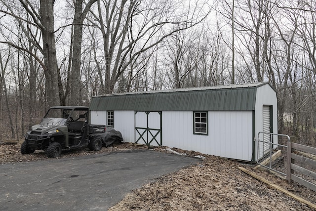 view of outbuilding featuring fence and an outdoor structure