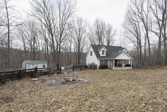 view of front facade featuring an outbuilding, fence, a storage shed, and a patio