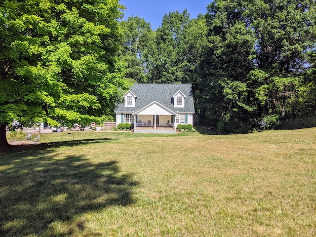 cape cod-style house featuring a front yard and covered porch