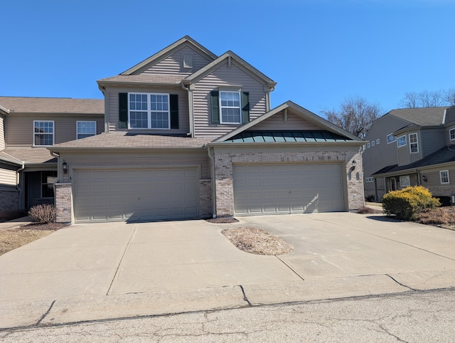 view of front of home with metal roof, concrete driveway, brick siding, and a standing seam roof