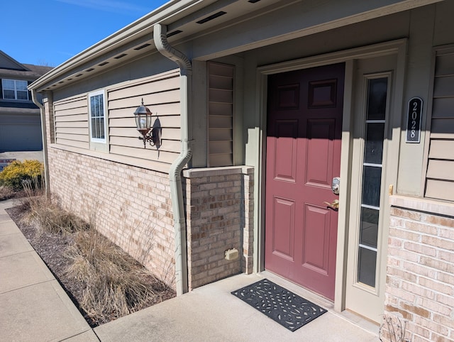 view of exterior entry with brick siding