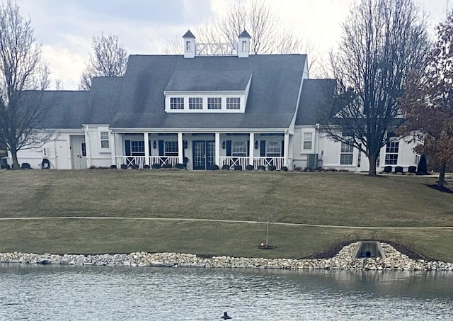 exterior space with a water view, covered porch, and a yard