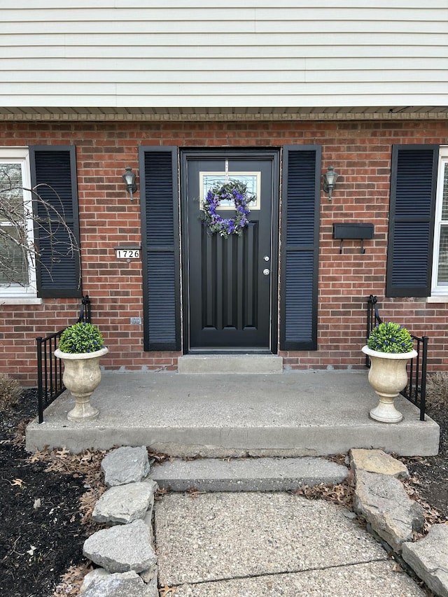 entrance to property featuring brick siding