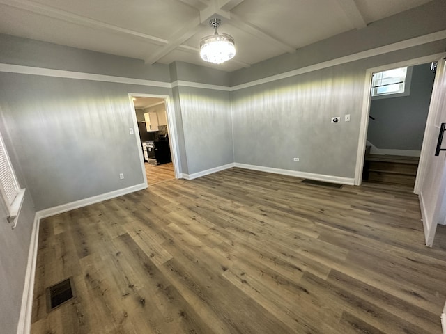 interior space with beam ceiling, wood finished floors, visible vents, and baseboards