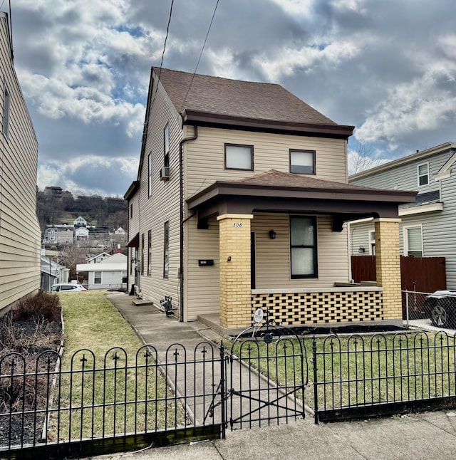 view of front of property with a fenced front yard, a gate, a shingled roof, and a front lawn