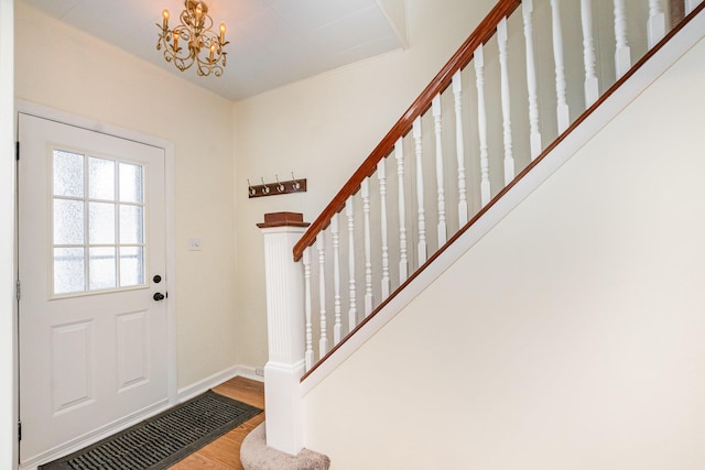 entryway with a chandelier, wood finished floors, visible vents, baseboards, and stairs