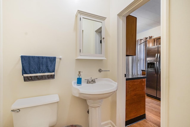 half bathroom featuring toilet and wood finished floors