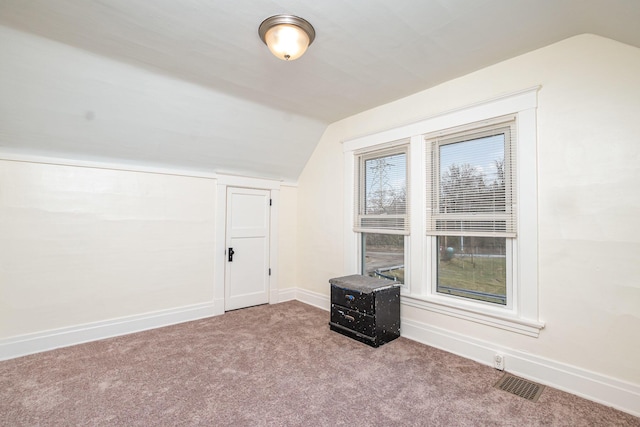 bonus room featuring baseboards, visible vents, vaulted ceiling, and carpet flooring