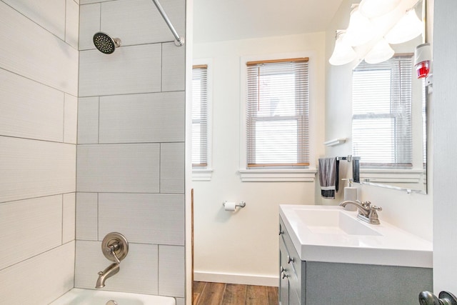 full bathroom with bathing tub / shower combination, vanity, baseboards, and wood finished floors