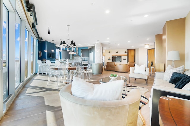 living room featuring light wood-style floors, recessed lighting, and a notable chandelier