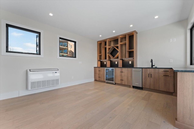 bar with recessed lighting, beverage cooler, a sink, heating unit, and light wood finished floors