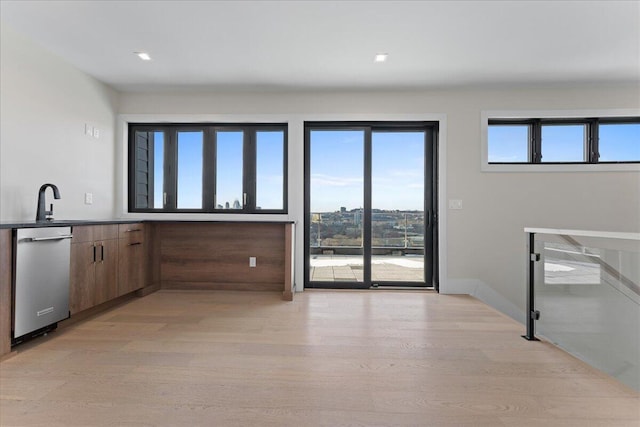 kitchen featuring light wood-type flooring, modern cabinets, baseboards, and stainless steel dishwasher