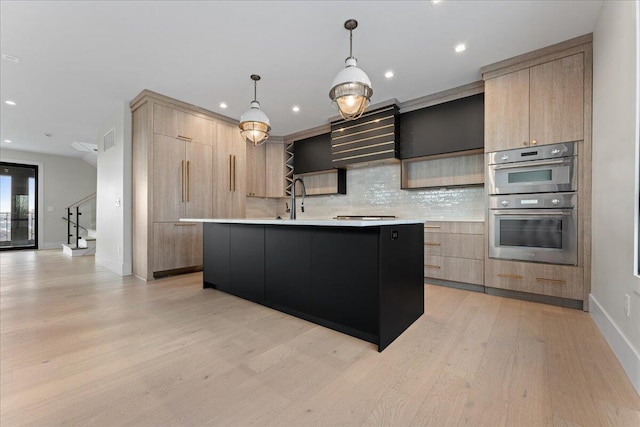 kitchen featuring light brown cabinetry, modern cabinets, light countertops, and double oven