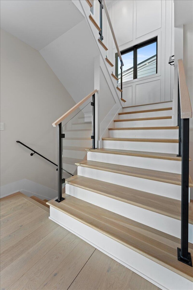 stairway featuring lofted ceiling and wood finished floors