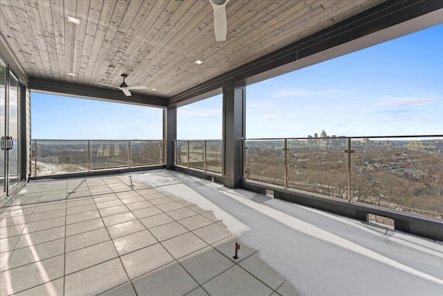 unfurnished sunroom featuring wood ceiling, plenty of natural light, and a ceiling fan