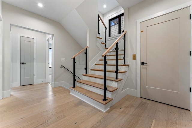 entrance foyer with baseboards, light wood finished floors, and stairs