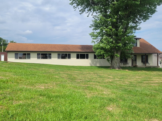 rear view of property with a lawn and a shingled roof