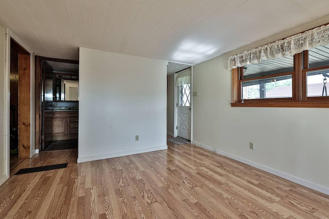 unfurnished room featuring baseboards and wood finished floors