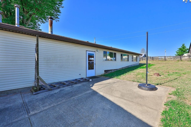 rear view of property featuring a yard, a patio, and fence