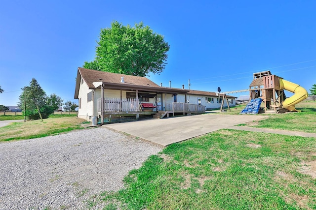 view of front of house featuring gravel driveway, a playground, and a front yard