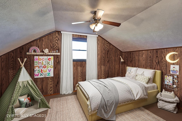 bedroom featuring vaulted ceiling, wood walls, and a textured ceiling