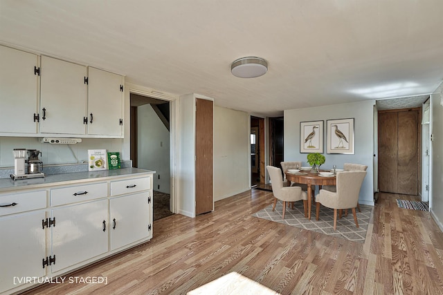 dining space with light wood finished floors and baseboards