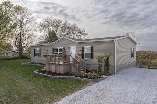 manufactured / mobile home with a front yard, crawl space, fence, driveway, and a wooden deck