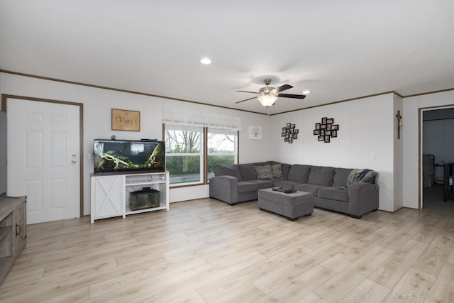 living room featuring light wood-style flooring, ornamental molding, a ceiling fan, and recessed lighting