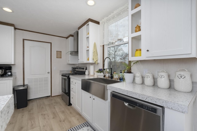 kitchen featuring stainless steel appliances, a sink, visible vents, white cabinets, and wall chimney exhaust hood