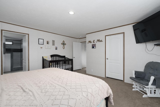 bedroom featuring dark carpet, connected bathroom, and crown molding