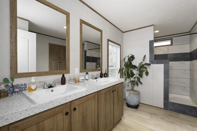 bathroom with crown molding, walk in shower, and a sink