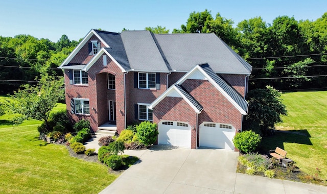 colonial home featuring concrete driveway, a front lawn, an attached garage, and brick siding