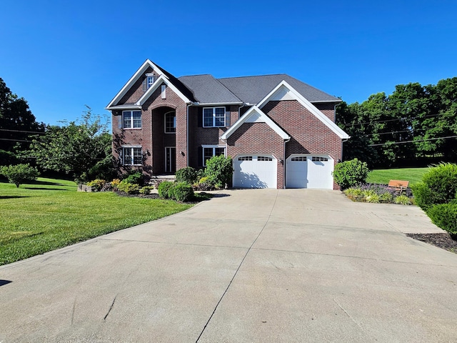 colonial home with a front yard, concrete driveway, and brick siding