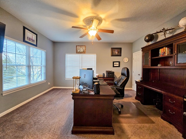 office with a textured ceiling, carpet floors, a ceiling fan, and baseboards