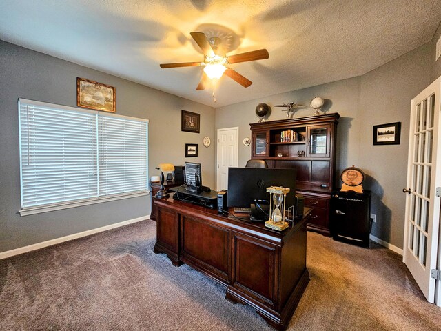 carpeted home office with ceiling fan, baseboards, and a textured ceiling