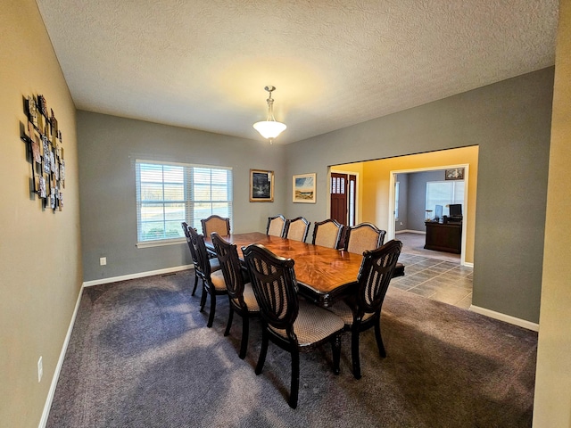 dining space with carpet flooring, a textured ceiling, and baseboards