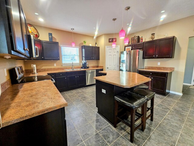 kitchen featuring a center island, stainless steel appliances, a sink, and light countertops