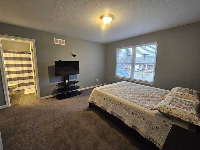 carpeted bedroom featuring a textured ceiling, ensuite bath, visible vents, and baseboards