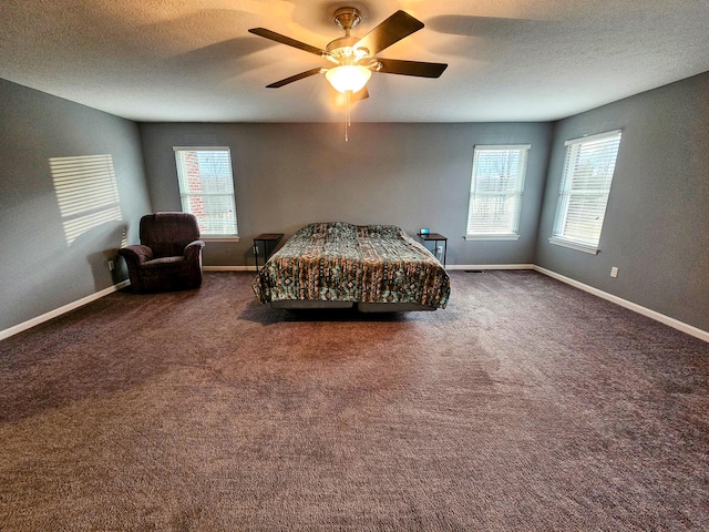 bedroom with a textured ceiling, multiple windows, baseboards, and carpet flooring