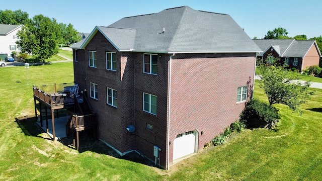 view of home's exterior with a garage, brick siding, a yard, and a wooden deck