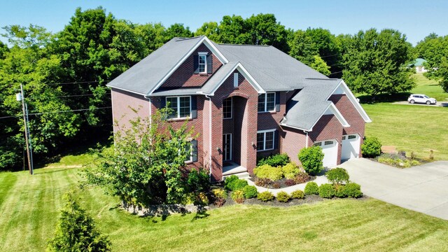 view of front of property with driveway, brick siding, and a front yard