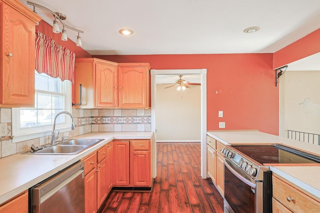 kitchen with appliances with stainless steel finishes, light countertops, a sink, and decorative backsplash