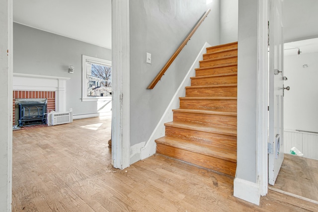 staircase featuring baseboard heating and wood finished floors