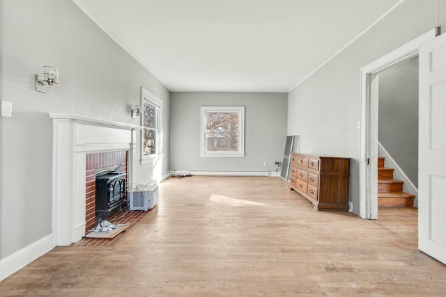 unfurnished living room featuring stairs, a baseboard radiator, wood finished floors, and baseboards